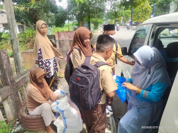 Mardiana Aksa bersama timnya membagikan alat tulis buat pelajar kurang mampu. (Foto: Ist)