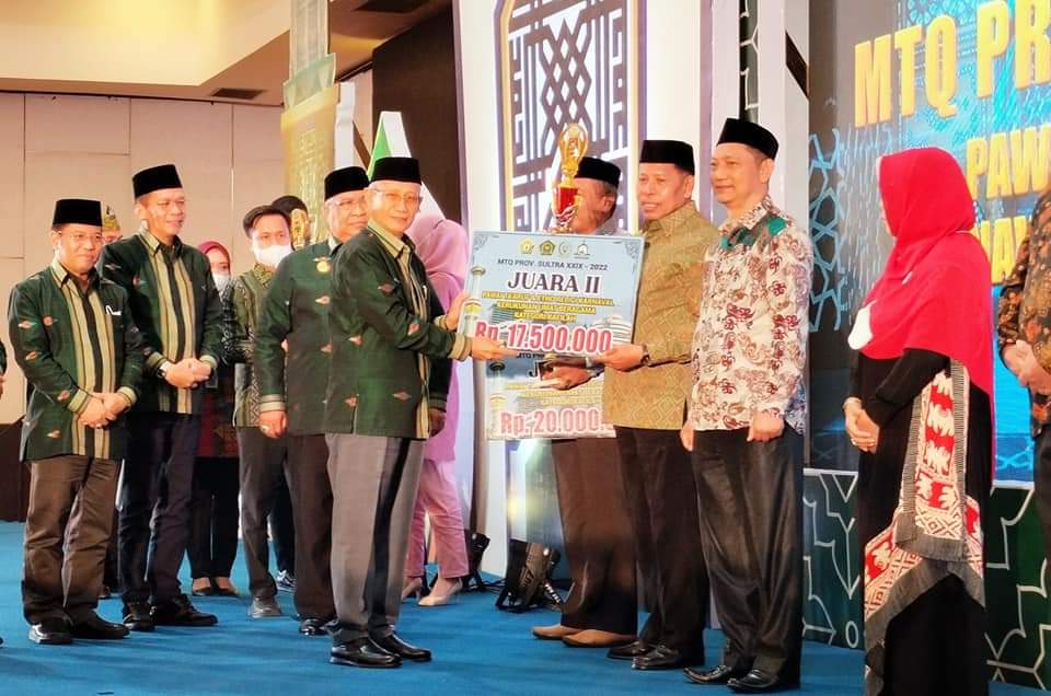 MENYERAHKAN: Wakil Gubernur Sulawesi Tenggara, Lukman Abunawas menyerahkan hadiah uang tunai Rp 17.500,000 kepada Wakil Bupati Buton Utara, Ahali di Hotel Claro Kendari, Rabu (10/8/2022). FOTO ISTIMEWA/Buton Pos