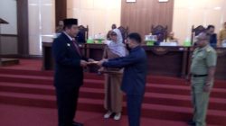 SETUJUI : Ketua DPRD Muna Irwan saat menyerahkan Raperda persetujuan LPJ Pelaksanaan APBD Tahun Anggaran 2021 kepada Bupati Muna LM. Rusman Emba. (Foto:Anurdin)