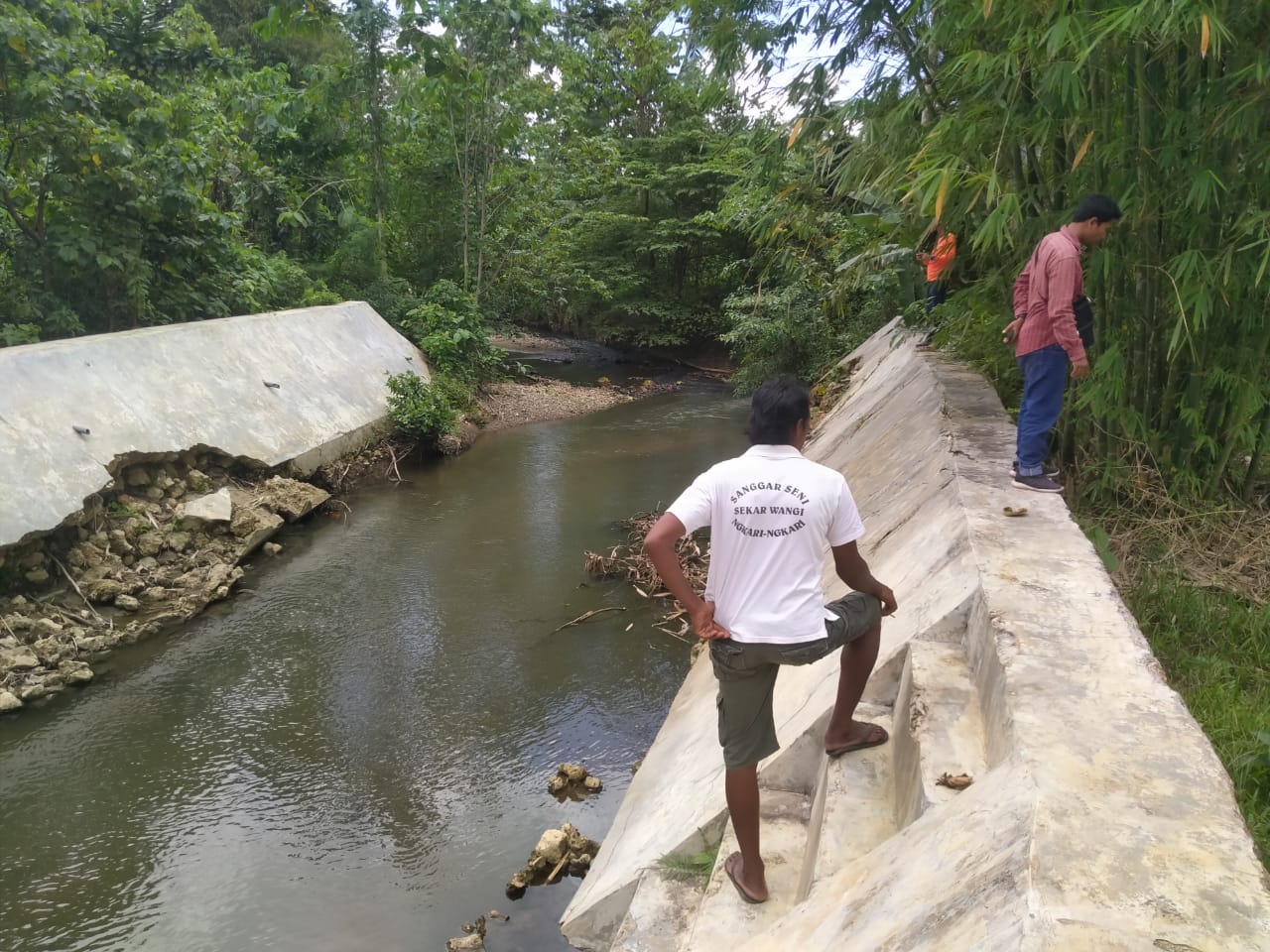 Ketua Subak Puri Sari Ngkari-Ngkari, Made Subawa (baju putih) menunjukkan talud sungai yang baru sepotong. Sungai itu selalu meluap ke area persawahan setiap hujan lama.(Foto Texandi)