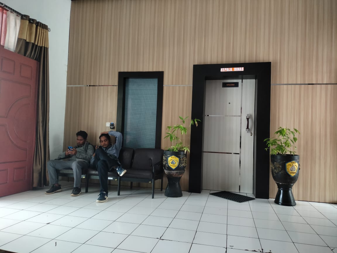 Dua wartawan sedang menunggu Kepala Disperkimtan Baubau, Siti Amalia Abibu, Rabu (16/11). Namun, hingga dua jam, wartawan tak berhasil mendapatkan tanggapan kepala dinas terkait temuan kelebihan pembayaran proyek jalan lingkungan sekira Rp 463 juta. (Foto Istimewa)