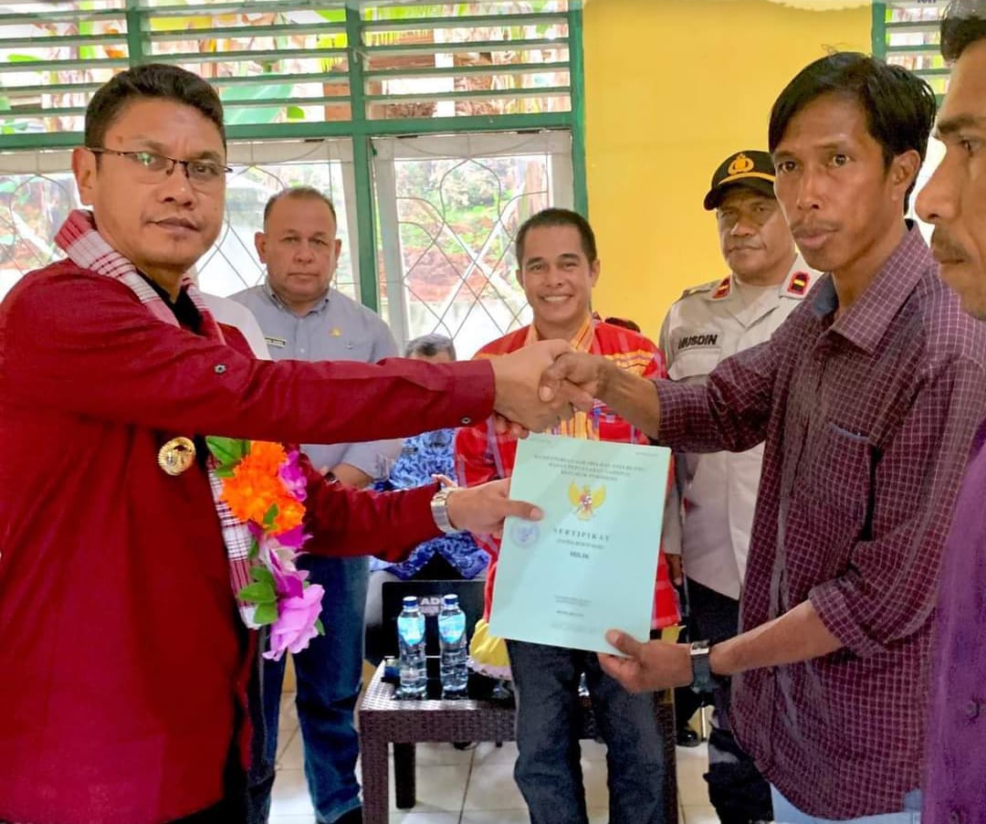 Pj Bupati Busel La Ode Budiman menyerahkan sertifikat lahan milik warga Lapandewa. (Foto Istimewa)